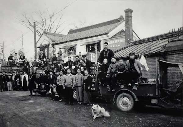 Around 1956. This is a photo taken in front of Aoki Sake Brewery’s storefront, which is still preserved today. The seventh brewer who was a little baby at that time is also in the picture! At that time, there were already so many people gathered to brew sake.